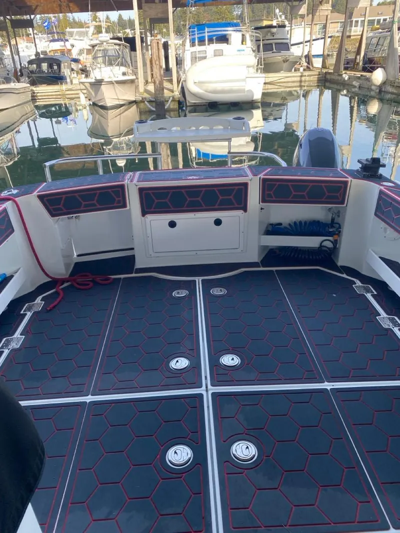 Slide: The Image of 2005 Ocean Sport Roamer 30 boat deck at marina, featuring hexagonal patterned flooring. - 19