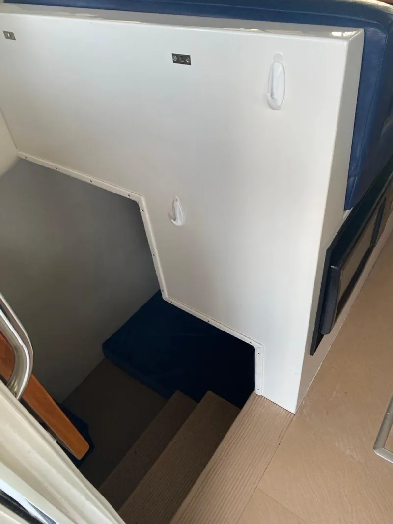 Slide: The Image of Stairway inside 2005 Ocean Sport Roamer 30 boat, featuring blue and white interior design. - 21