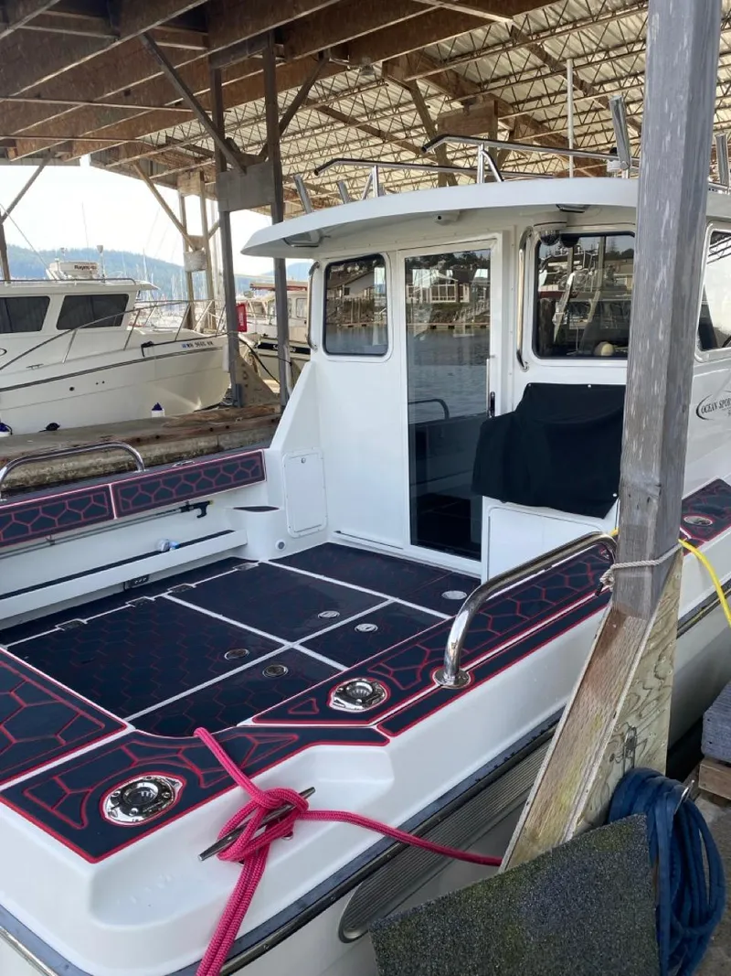 Slide: The Image of 2005 Ocean Sport Roamer 30 boat docked in a marina under a wooden shelter. - 5