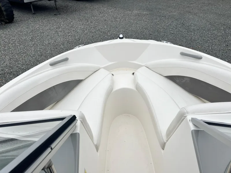 Slide: The Image of 2009 Bayliner 185 boat interior with white seating and open bow design. - 10