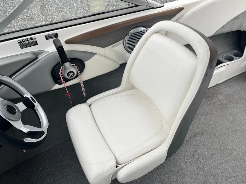 Slide: The Image of 2009 Bayliner 185 boat interior with white captain's chair and steering wheel. - 12