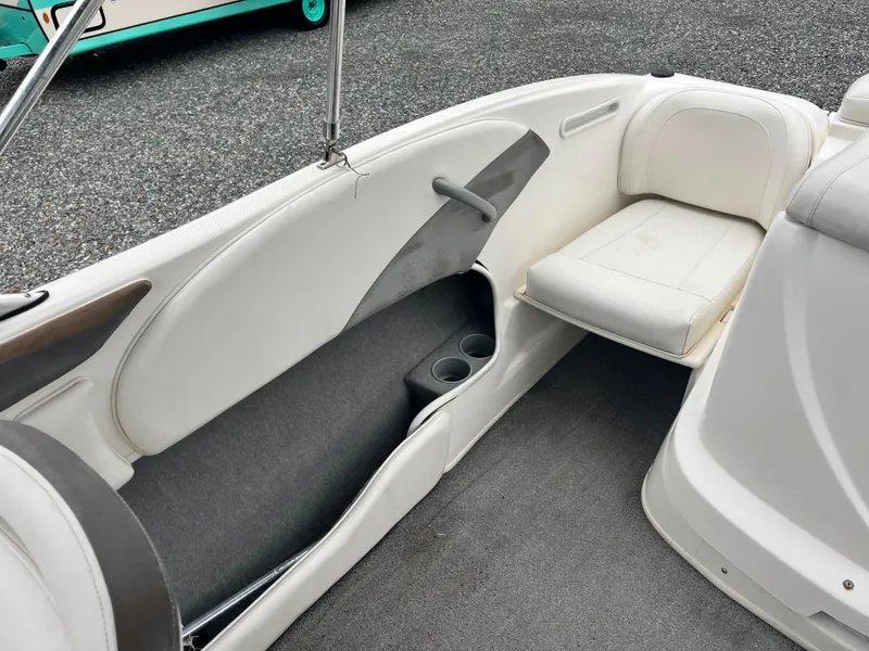 Slide: The Image of 2009 Bayliner 185 boat interior with white seating and cup holders. - 13