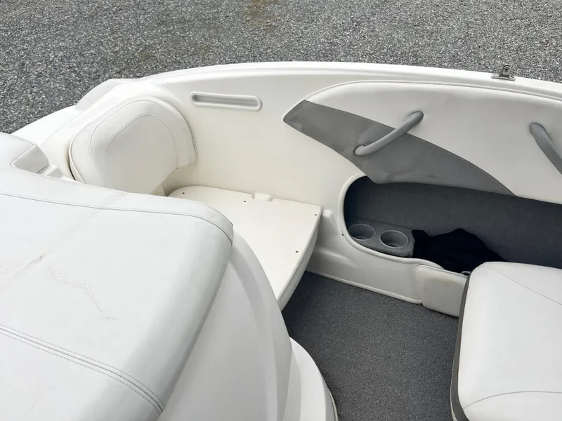 Slide: The Image of 2009 Bayliner 185 boat interior with white seating and cup holders. - 15