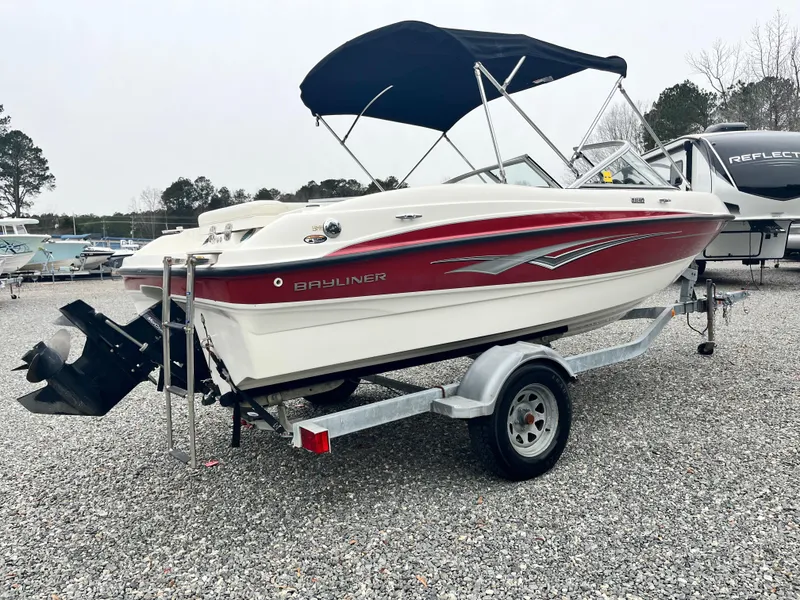 Slide: The Image of 2009 Bayliner 185 boat on trailer with canopy, parked on gravel lot. - 3