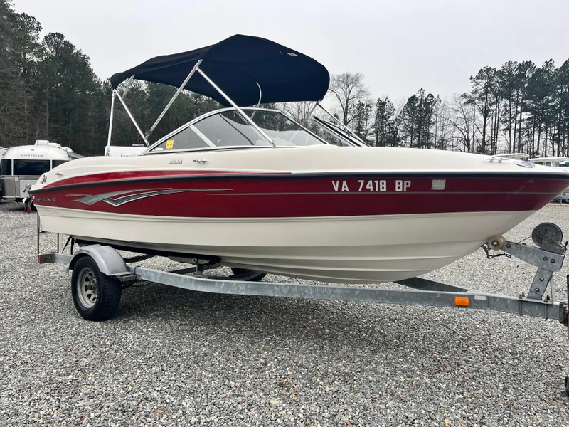 Slide: The Image of 2009 Bayliner 185 boat with red accents on a trailer, parked outdoors. - 4