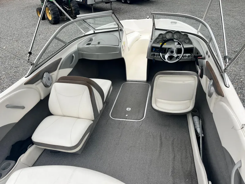 Slide: The Image of 2009 Bayliner 185 boat interior with white seating and steering console. - 9