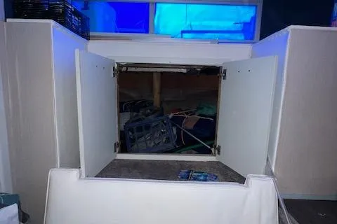 Slide: The Image of Open cabinet with cluttered storage inside, under a blue-tinted window. - 10