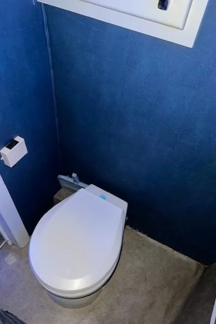 Slide: The Image of Modern bathroom with blue walls, featuring a white toilet and toilet paper holder. - 14