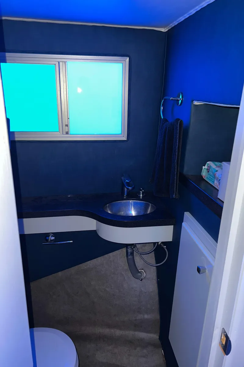 Slide: The Image of Small blue bathroom with sink, mirror, and window; modern design, 1977 Gibson Standard. - 18