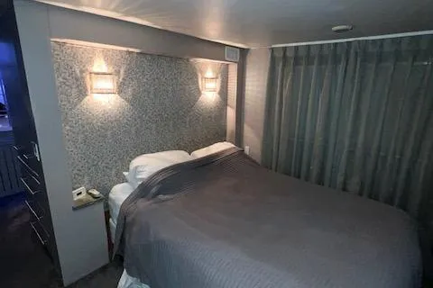 Slide: The Image of A cozy bedroom with a double bed, gray bedding, and soft lighting. - 22