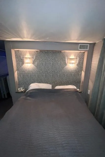 Slide: The Image of Cozy bedroom with gray bedding, textured wall, and soft lighting. - 26