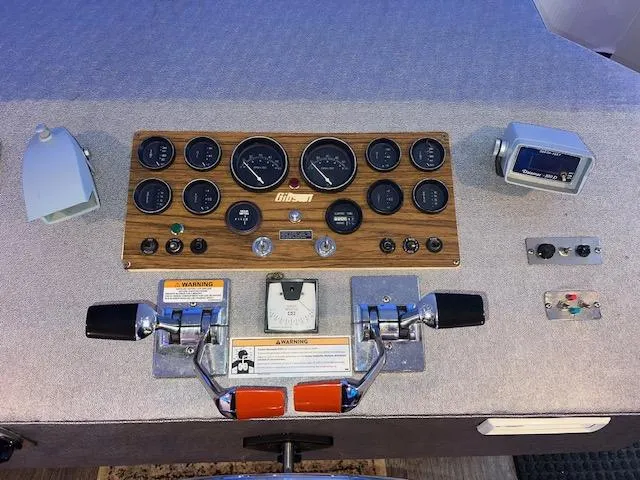 Slide: The Image of 1977 Gibson Standard boat dashboard with gauges, controls, and warning labels. - 27