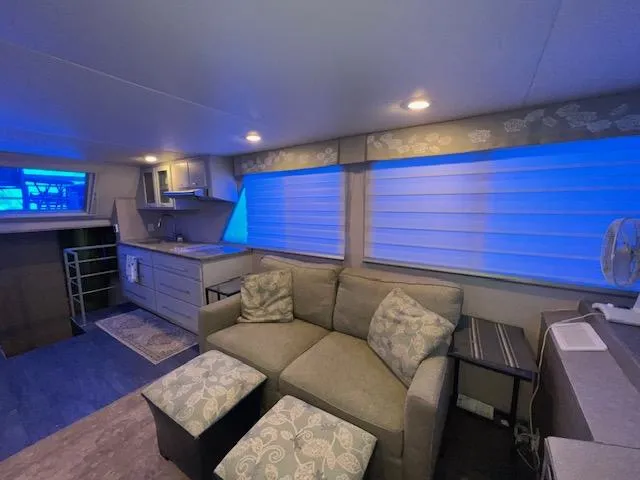 Slide: The Image of Cozy 1977 Gibson Standard boat interior with sofa, kitchenette, and blue-lit windows. - 29