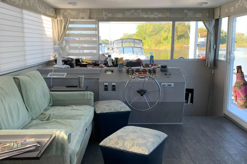 Slide: The Image of Interior of a 1977 Gibson Standard boat with helm, sofa, and scenic window view. - 3