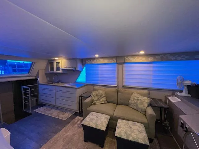 Slide: The Image of 1977 Gibson Standard boat interior with cozy seating, kitchenette, and ambient blue lighting. - 30