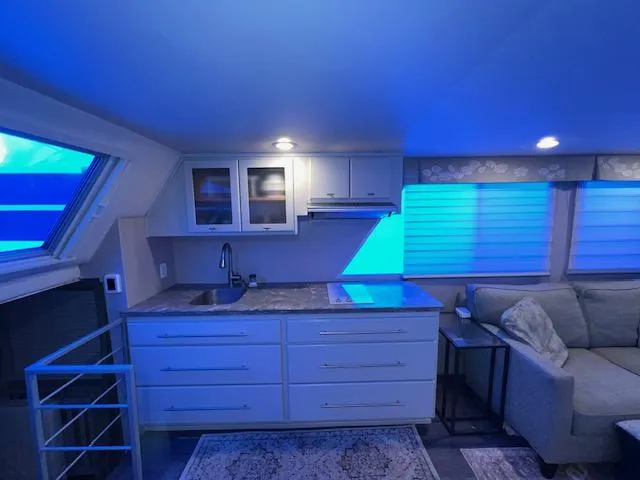 Slide: The Image of Modern kitchen and living area in a 1977 Gibson Standard boat, featuring blue ambient lighting. - 31