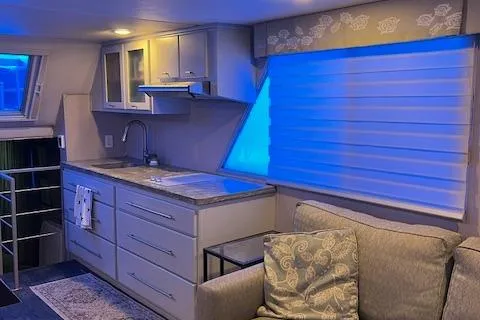 Slide: The Image of Modern kitchen interior in a 1977 Gibson Standard boat with blue lighting. - 41