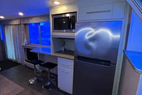 Slide: The Image of Modern kitchen with stainless steel appliances, bar stools, and ambient lighting. - 48