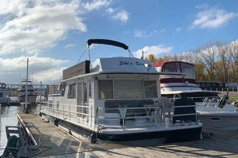 Slide: The Image of 1977 Gibson Standard houseboat docked under a partly cloudy sky. - 6