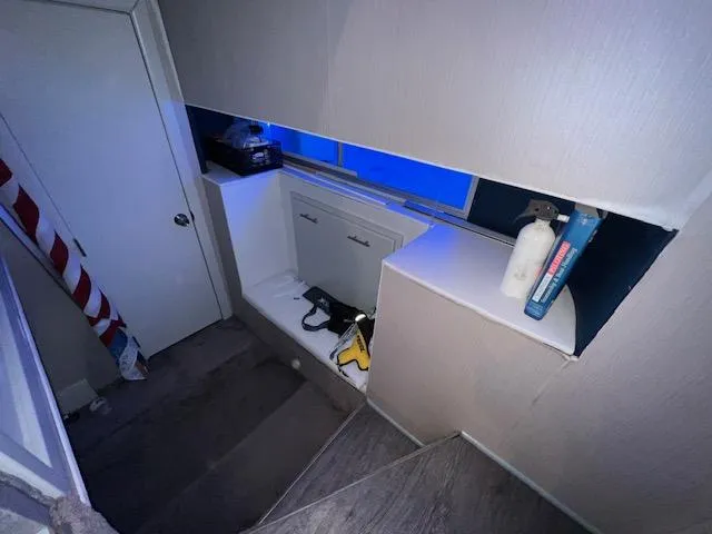 Slide: The Image of Dimly lit stairwell with storage area, featuring a 1977 Gibson Standard guitar case. - 7