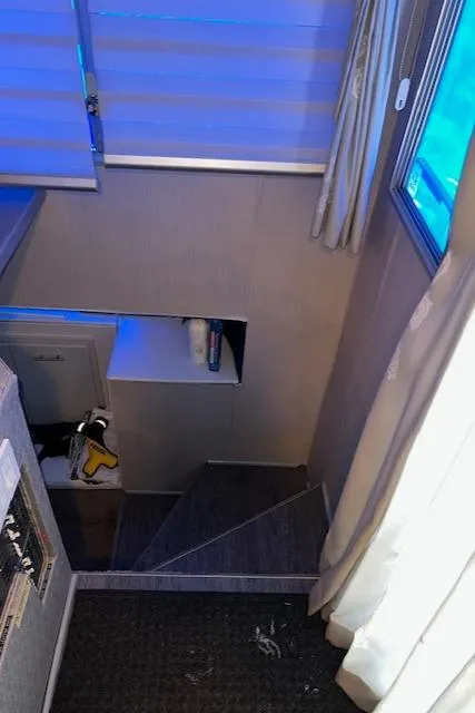 Slide: The Image of Narrow staircase with modern decor and blue lighting, featuring a small shelf and window. - 8