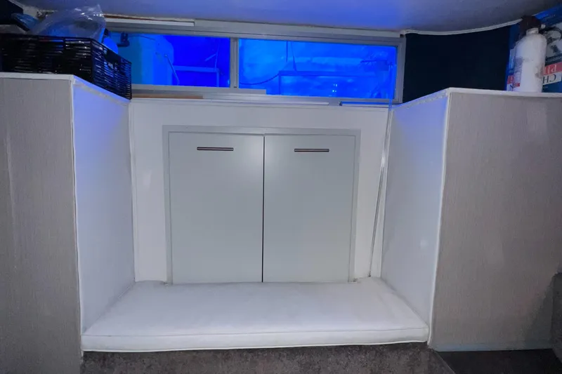 Slide: The Image of Interior of a 1977 Gibson Standard boat with storage cabinets and blue-tinted windows. - 9