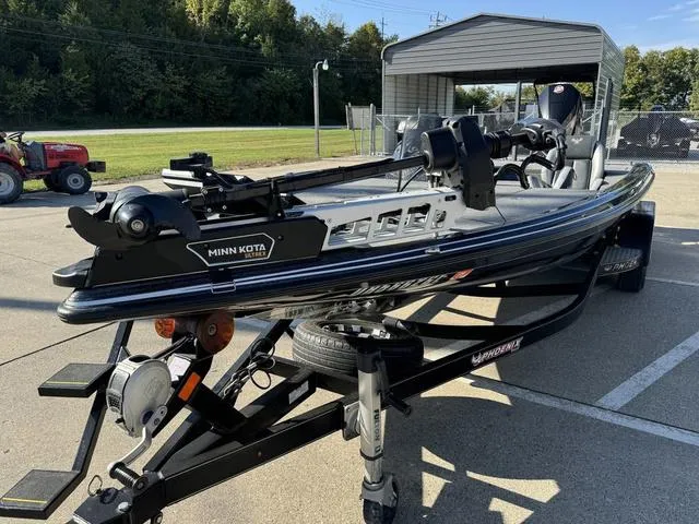 Slide: The Image of 2021 Phoenix 921 ELITE boat with Minn Kota motor on trailer, parked outdoors. - 11