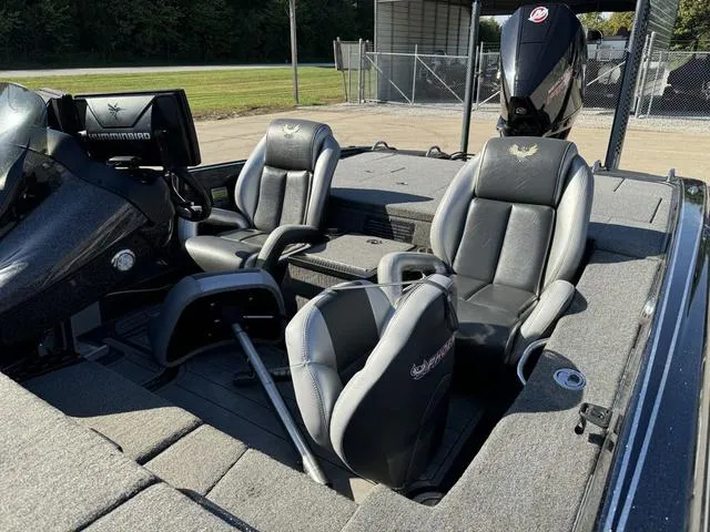 Slide: The Image of 2021 Phoenix 921 ELITE boat interior with black and gray seating, steering console, and motor. - 15