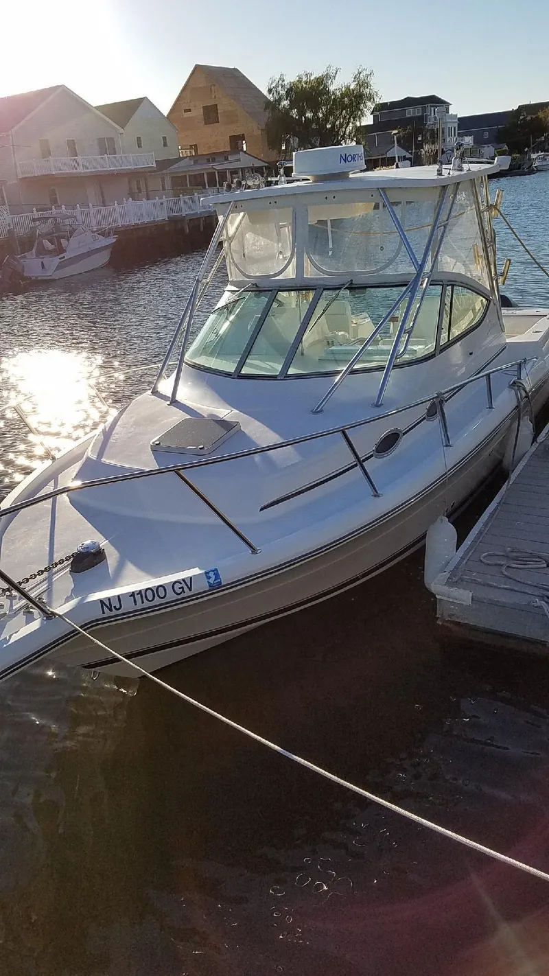 Slide: The Image of 2004 Stamas 310 Express boat docked in a sunny marina setting. - 6