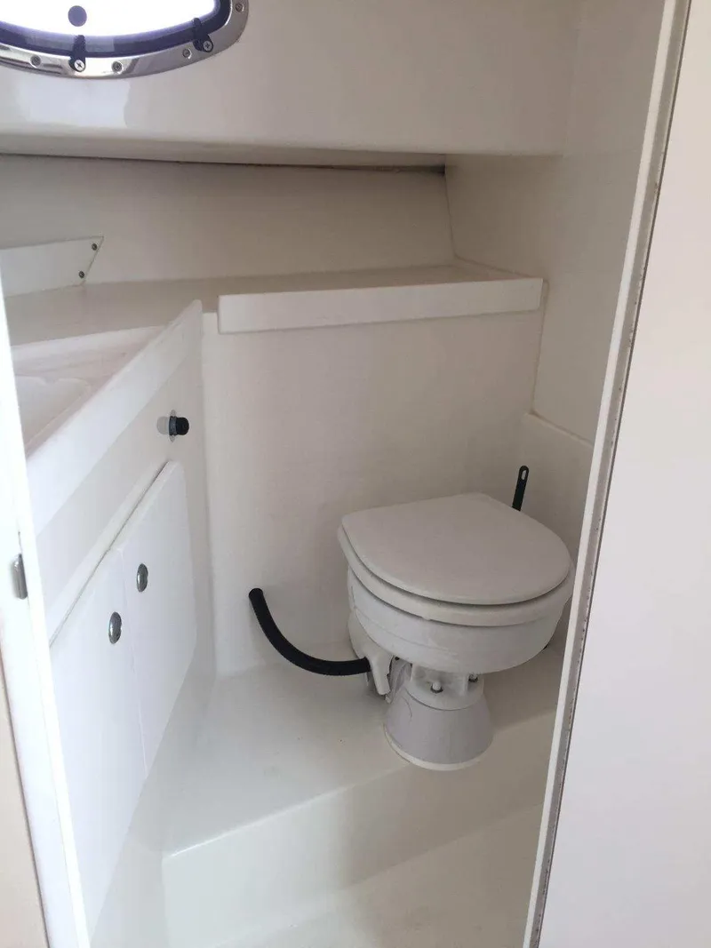 Slide: The Image of 2004 Stamas 310 Express boat bathroom with toilet and storage cabinet. - 8