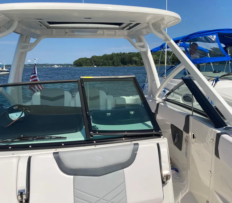 Slide: The Image of 2020 Chaparral 280 OSX boat on a sunny lake with American flag. - 13