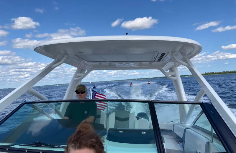 Slide: The Image of 2020 Chaparral 280 OSX boat cruising on a sunny day with American flag. - 4