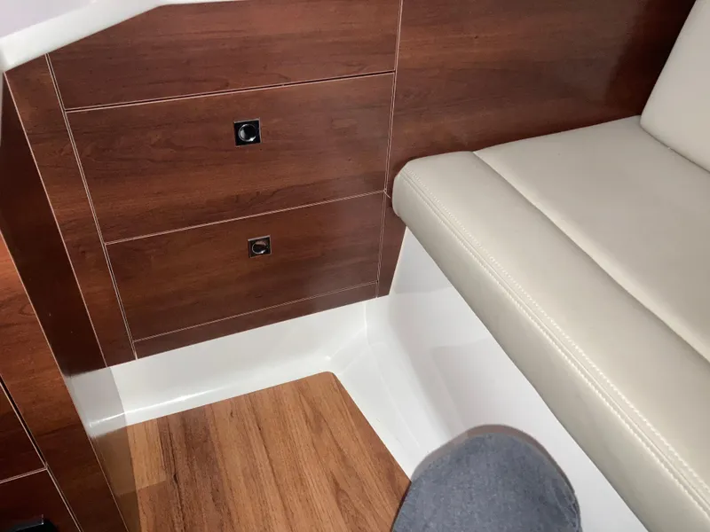 Slide: The Image of Interior of 2020 Chaparral 280 OSX boat with wood paneling and beige seating. - 6