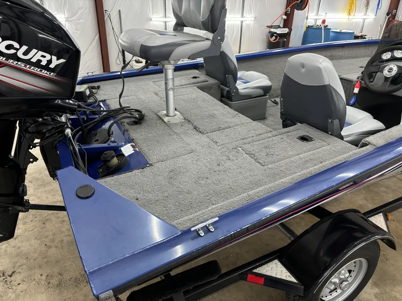 Slide: The Image of 2012 Tracker Pro Team 175 TF boat interior with Mercury engine, gray seating, and carpeted deck. - 9