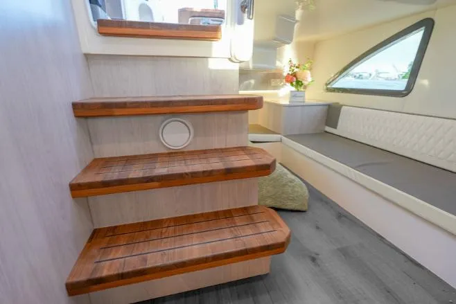 Slide: The Image of Interior of 2025 Hanover 387 Grey & Black Edition Outboard, featuring wooden steps and seating area. - 12