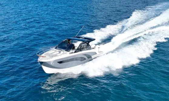 Slide: The Image of 2025 Hanover 387 Grey & Black Edition Outboard cruising on blue ocean waters. - 2