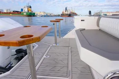 Slide: The Image of 2025 Hanover 387 Grey & Black Edition Outboard, featuring sleek seating and wooden table on deck. - 7