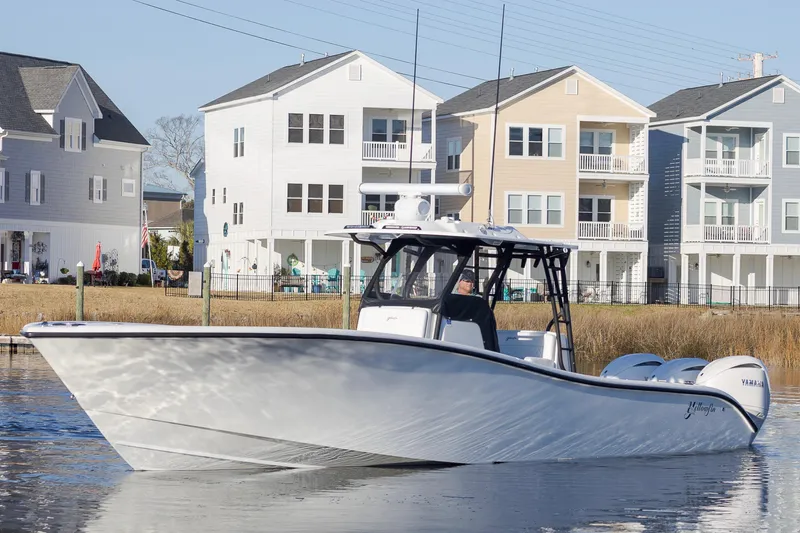 Slide: The Image of 2020 Yellowfin 36 Offshore boat on water near coastal homes. - 5