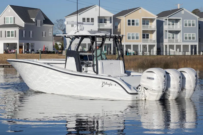 Slide: The Image of 2020 Yellowfin 36 Offshore boat with triple Yamaha engines, docked near waterfront homes. - 9