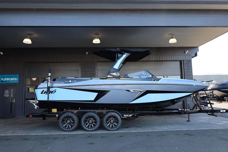 The Image of 2025 Tigé 24RZX boat on trailer, sleek design, parked in a garage. - 1