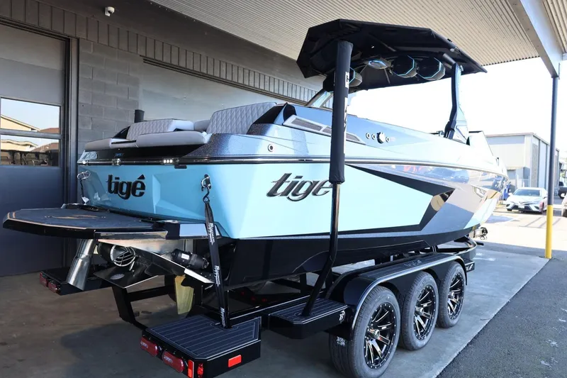 Slide: The Image of 2025 Tigé 24RZX boat on trailer, sleek design, blue and black color scheme. - 13