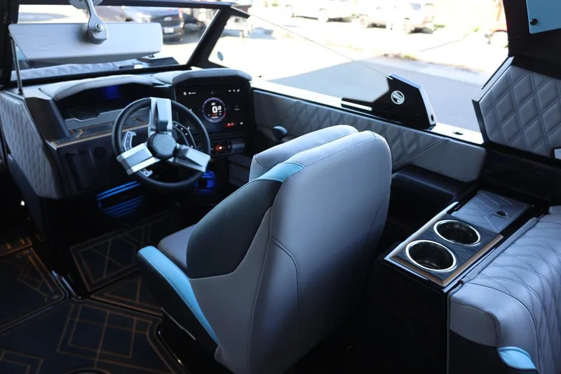 Slide: The Image of 2025 Tigé 24RZX boat interior with modern dashboard, steering wheel, and cup holders. - 27