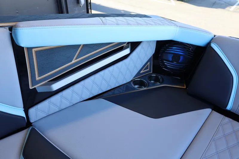 Slide: The Image of 2025 Tigé 24RZX boat interior with modern design, featuring blue and gray upholstery and cup holders. - 31