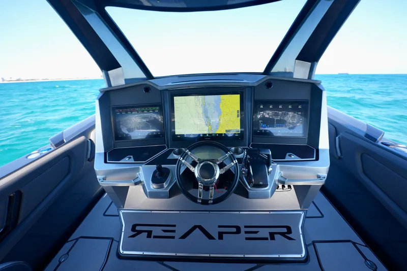 Slide: The Image of 2024 Adrenaline 47 Reaper boat dashboard with advanced navigation screens on open water. - 21