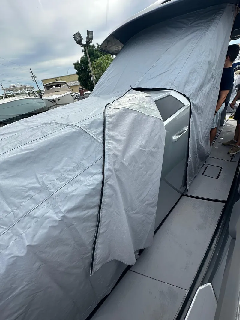 Slide: The Image of 2024 Adrenaline 47 Reaper boat covered with protective tarp on deck. - 49