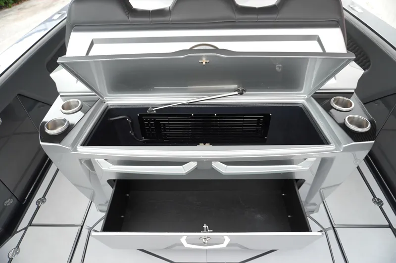 Slide: The Image of 2024 Adrenaline 47 Reaper boat interior with open storage compartments and cup holders. - 8