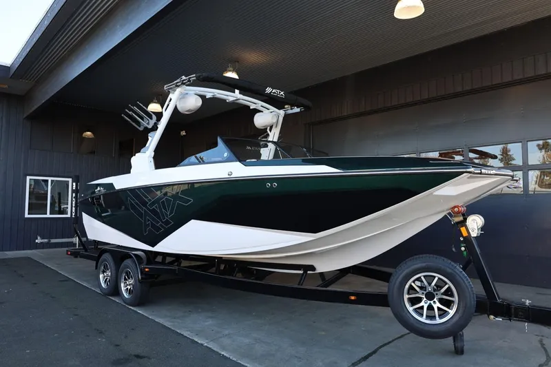 Slide: The Image of 2025 ATX Surf Boats 24 Type-S on trailer, parked outside a building. - 4