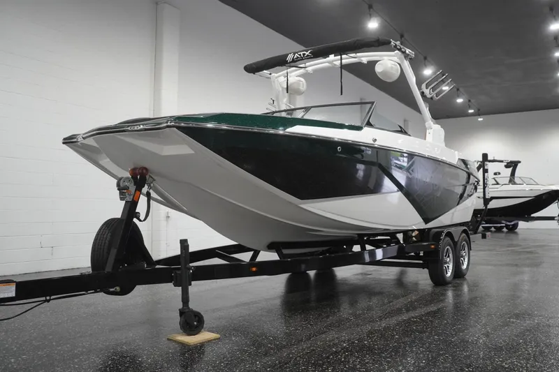 Slide: The Image of 2025 ATX Surf Boats 24 Type-S on trailer in showroom, sleek design, black and white finish. - 55