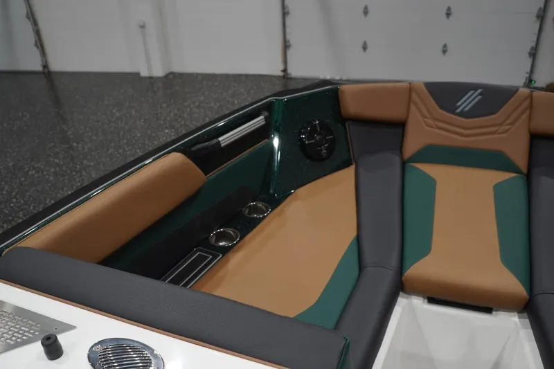Slide: The Image of 2025 ATX Surf Boats 24 Type-S interior with tan and green seating, cup holders, and sleek design. - 79