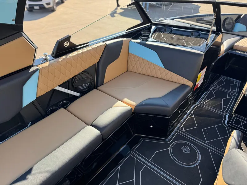 Slide: The Image of 2023 Tigé Z3 boat interior with stylish tan and blue seating, geometric flooring design. - 12